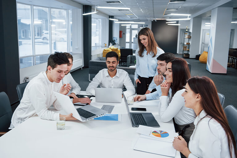 DotClick: A diverse group of software developers brainstorming and working together on laptops.